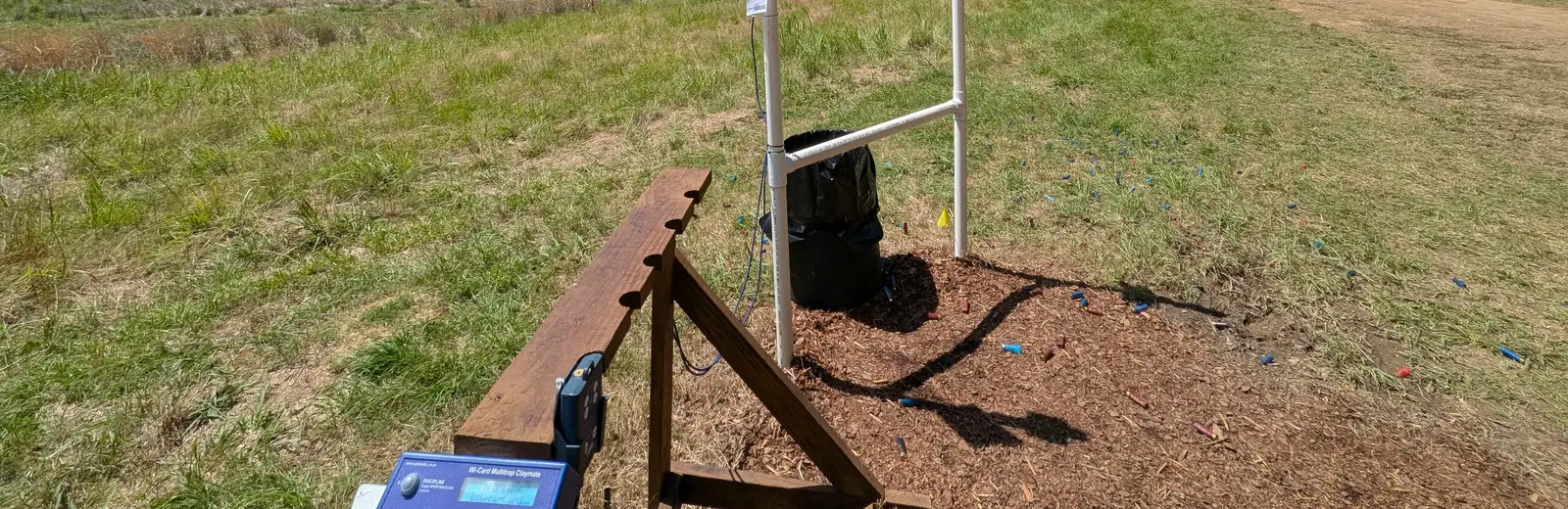 A sporting clays shooting station with spent shells at the edge of a field